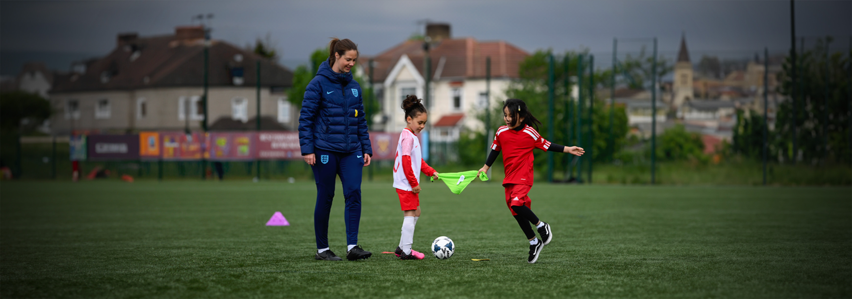 A coach watches as two players hold either end of a bib