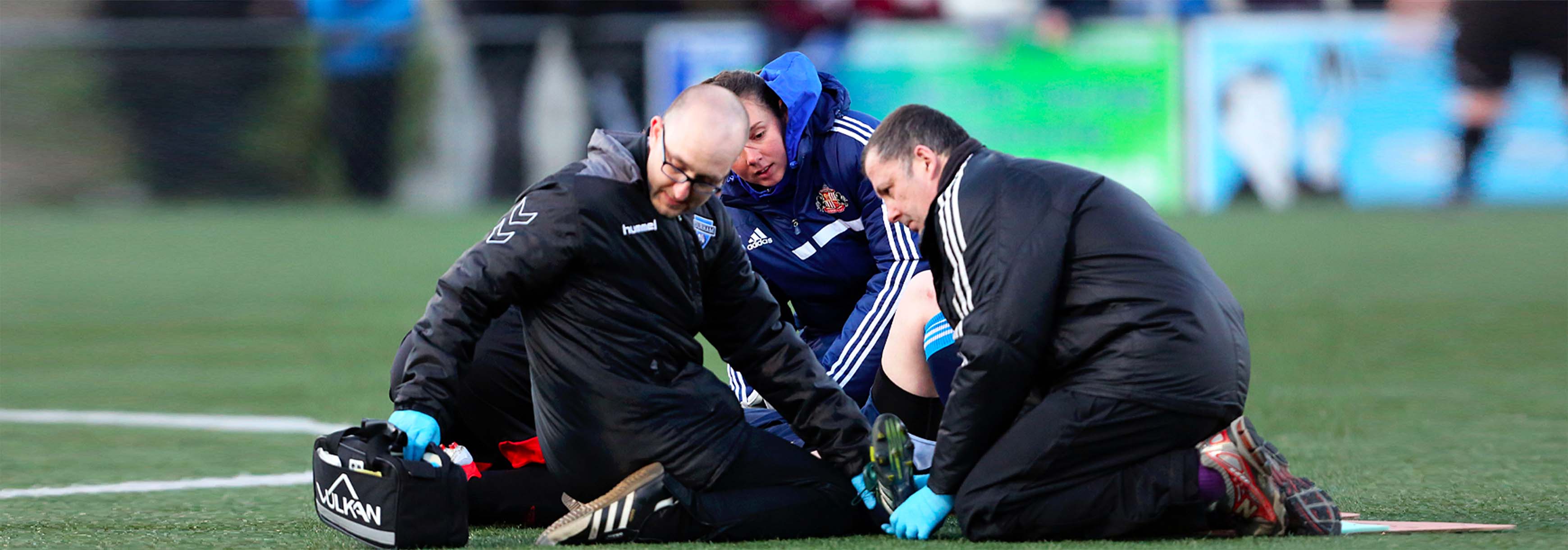 Medics treating an injured player during a football match