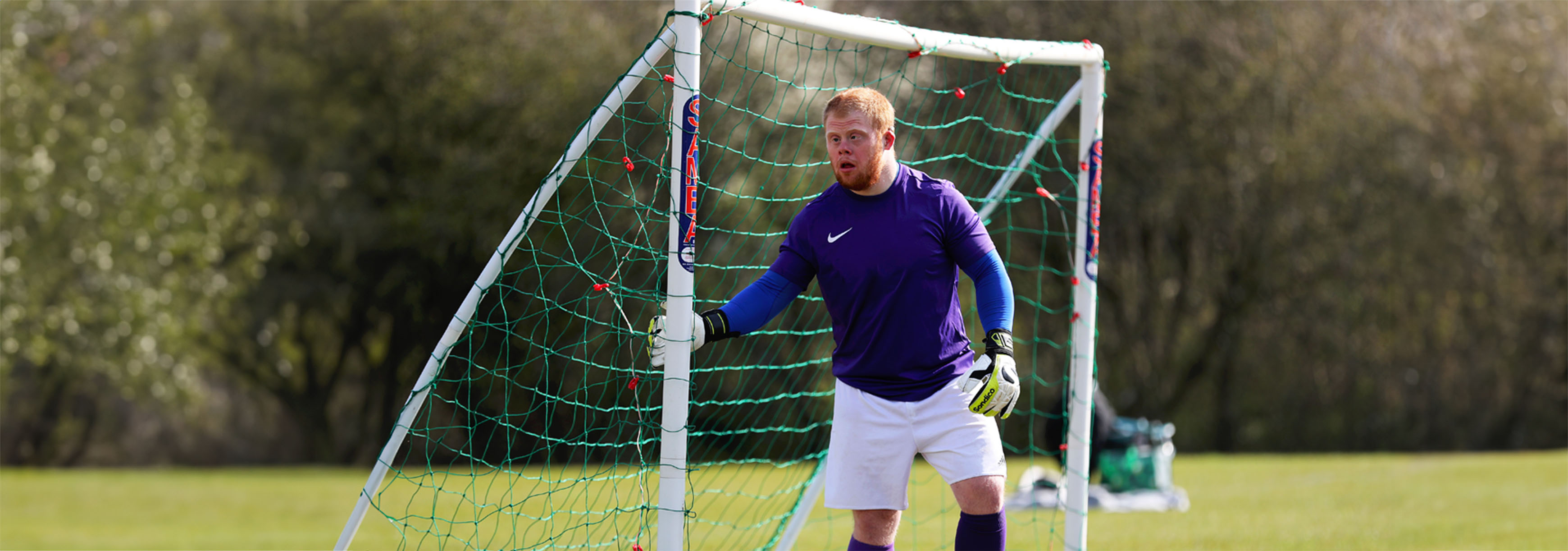 A goalkeeper stands at his near post as he waits for the ball to be crossed in during a grassroots inclusive football match.