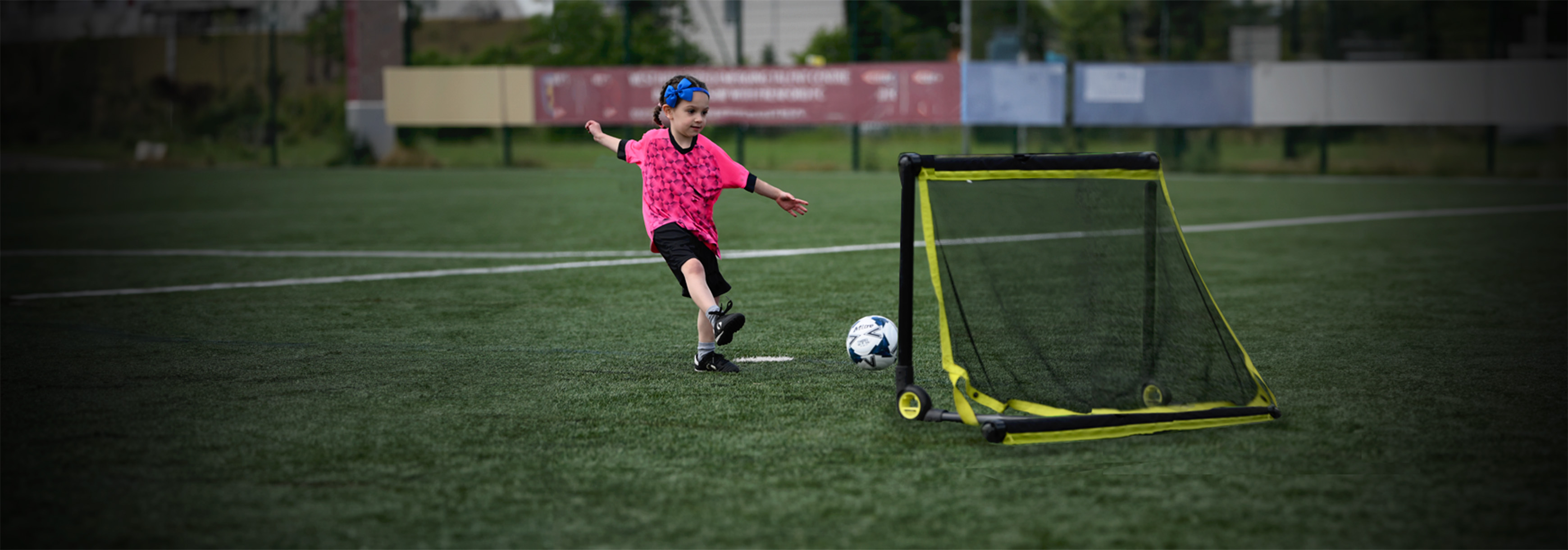 A player kicks a ball into a mini-goal.