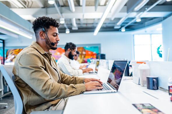 Young man working on call center at office