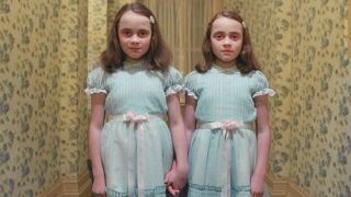 Twins standing in a corridor during one of the best horror movies of all time, The Shining.