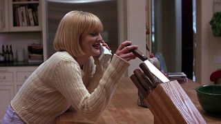 Drew Barrymore holding a kitchen knife while talking on the phone to Ghostface during Scream.