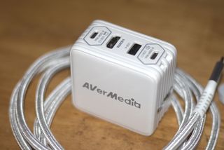 The AVerMedia Elite Go GC313 Pro charging brick and capture card combo in white.