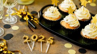 Frosted cupcakes with candles spelling out the year '2025'