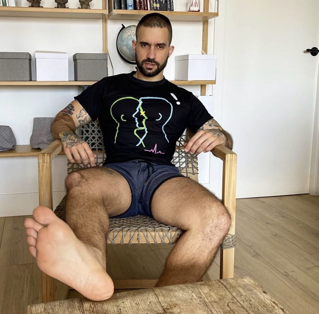 Tattooed and bearded elreydelosgatos puts his bare sole up