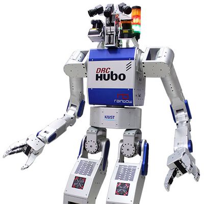 A 1.45 meter tall bipedal humanoid robot with a silver body, gripper hands and cameras and sensors in its head.