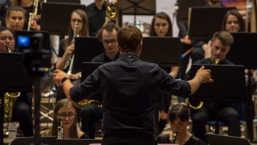 Man conducting Sheffield university wind orchestra 