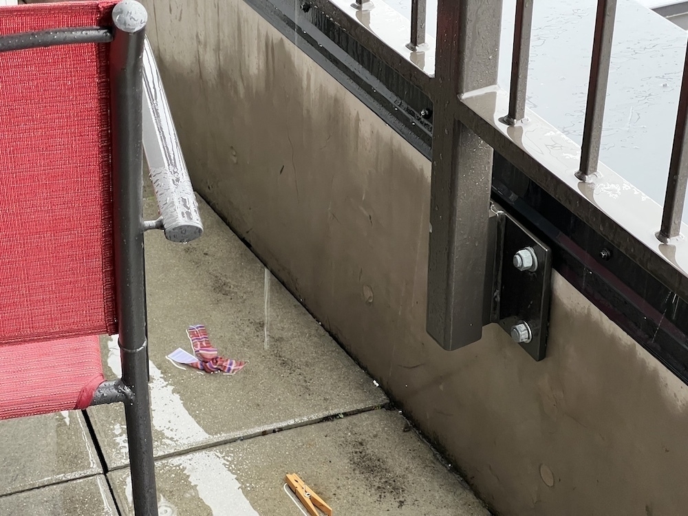 Rainy day, shot of some small trash on a concrete balcony.