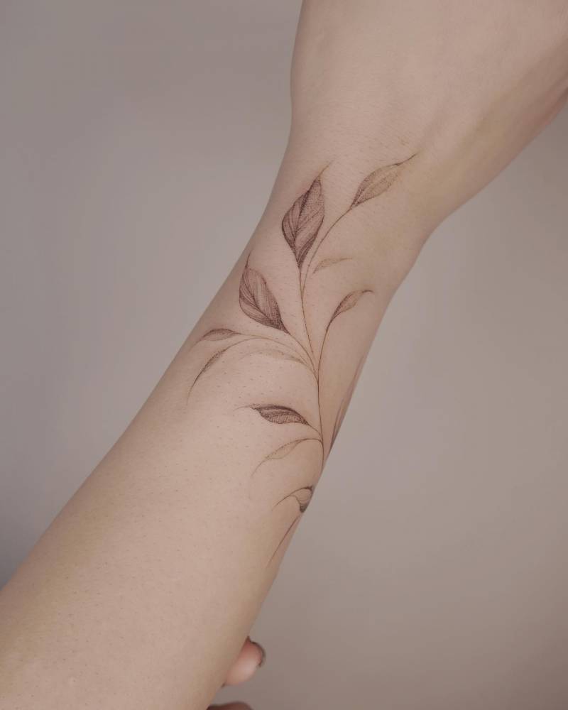 Illustrative style leaves tattoo located on the wrist.