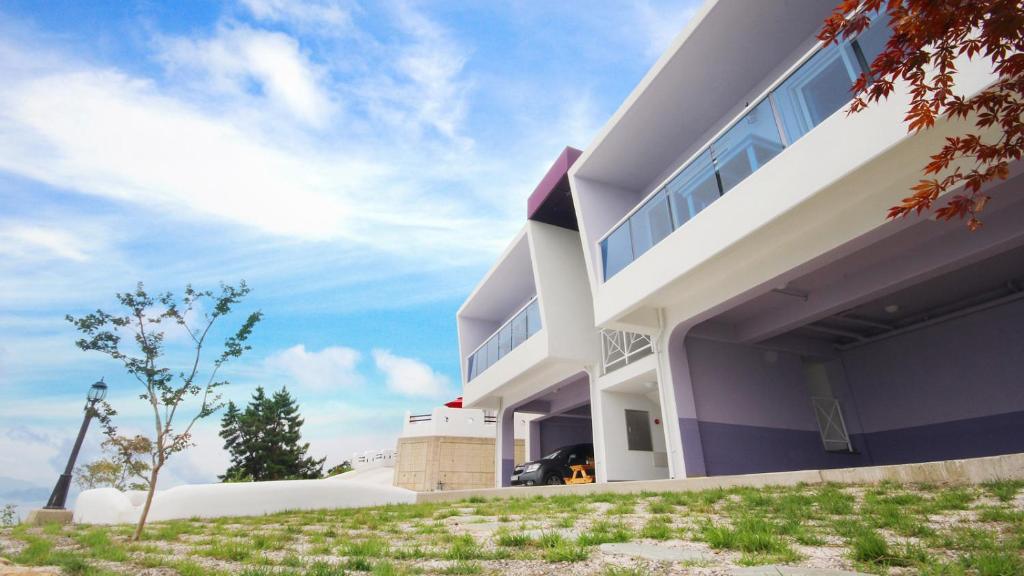 una gran casa blanca con un cielo de fondo en Blue & White Pension en Namhae