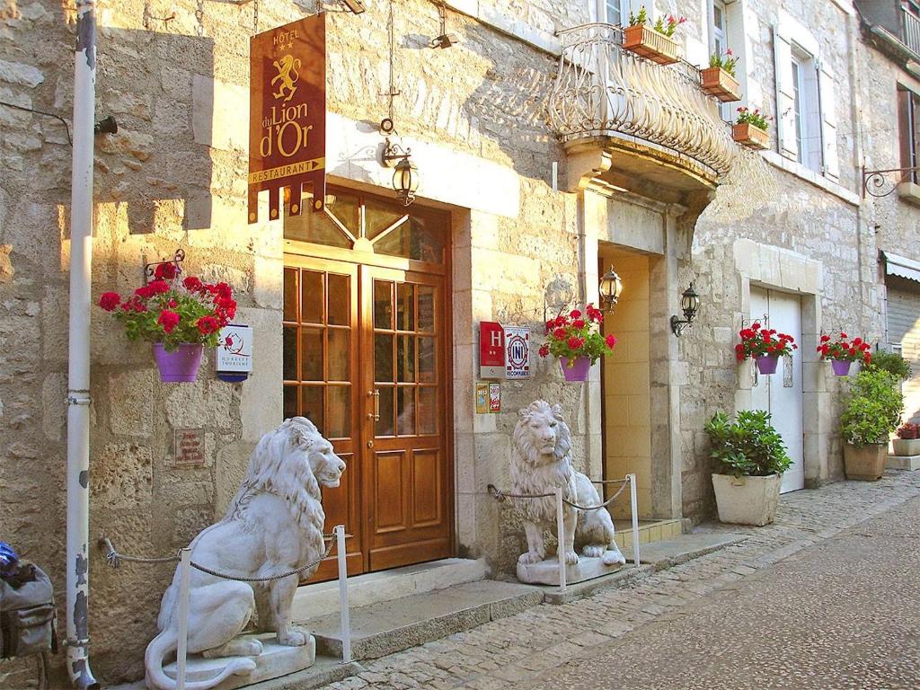 due statue di leoni davanti a un edificio di Hotel du Lion d'Or a Rocamadour