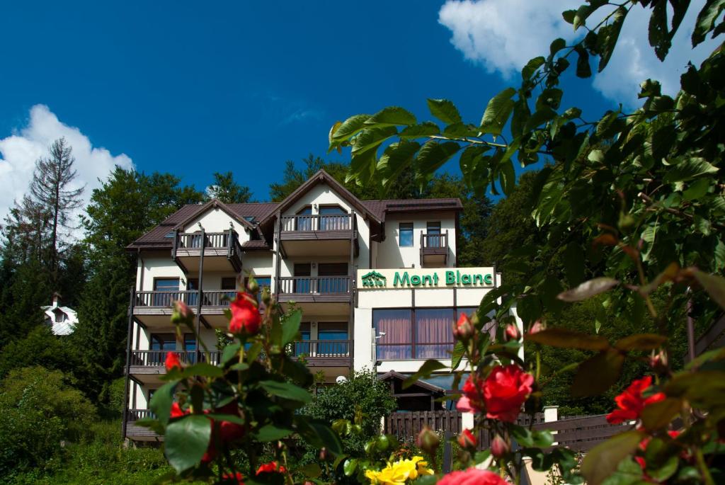 una posada en la colina con flores delante en Hotel Mont Blanc en Predeal