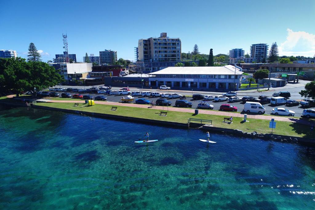 a group of people in boats in a river with a parking lot at Lakes and Ocean Hotel Forster in Forster