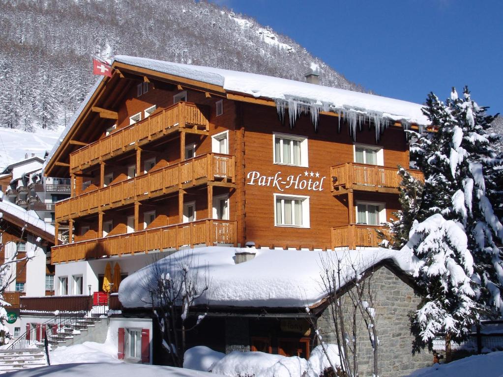 d'un grand bâtiment en bois recouvert de neige. dans l'établissement Park-Hotel Saas- Fee, à Saas-Fee