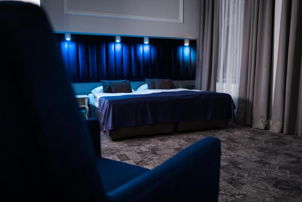 een hotelkamer met 2 bedden en blauwe verlichting bij City Boutique Hotel in Zielona Góra