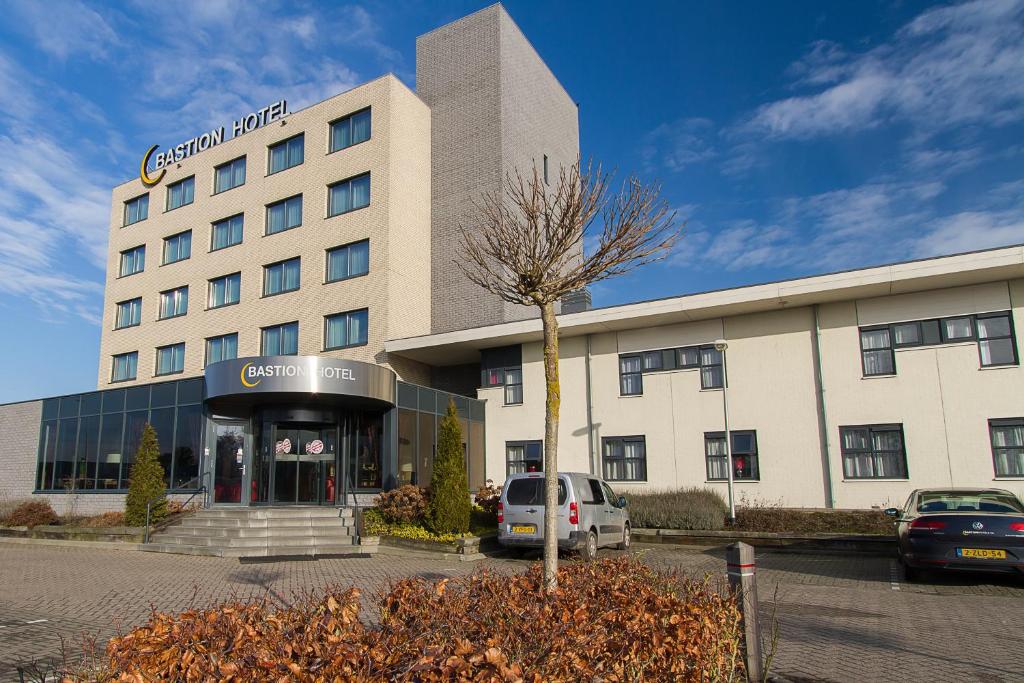 a building with a car parked in front of it at Bastion Hotel Groningen in Groningen