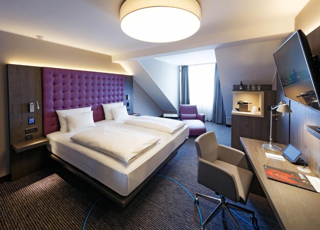 Pokój hotelowy z dużym łóżkiem i biurkiem w obiekcie Hotel Stadt München w mieście Düsseldorf