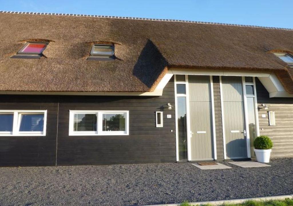 a brown house with a brown roof at Retro farmhouse Cadzand, Koolse Hoeve 1H in Cadzand