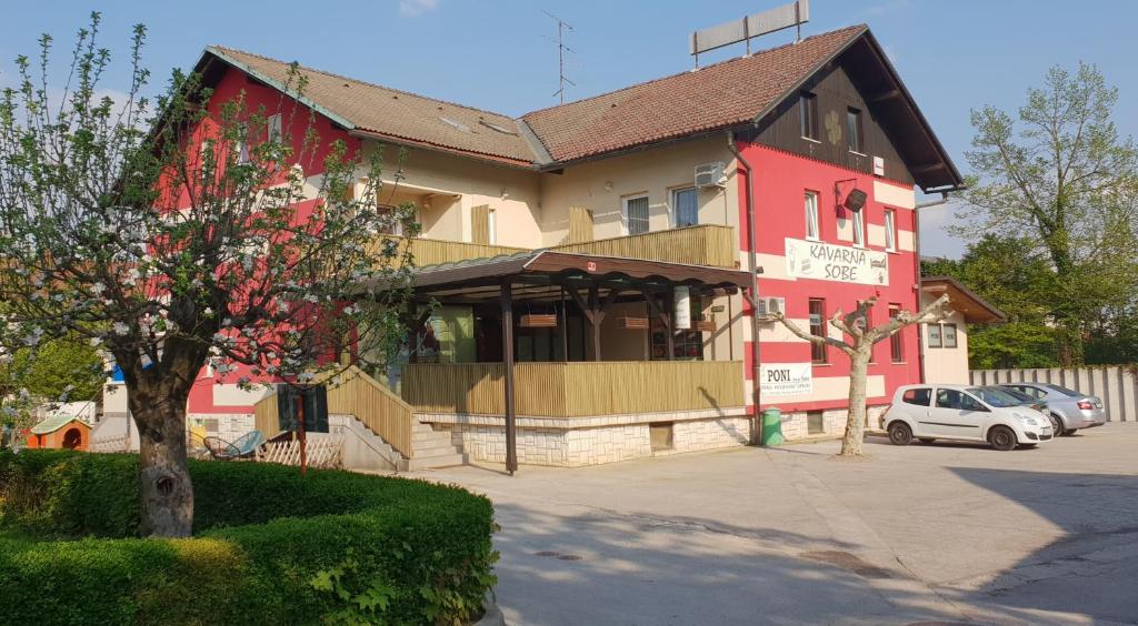 een gebouw met een rood en geel gebouw bij PONI NAKLO - Sobe Marinšek in Naklo