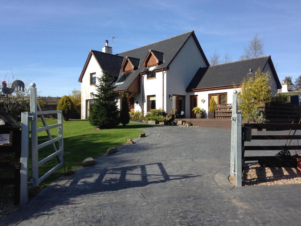 a white house with a fence and a driveway at Old Mills Garden in Elgin