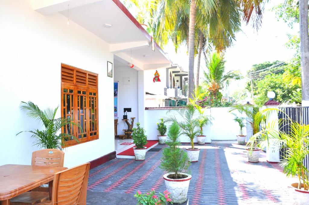 een huis met een binnenplaats met potplanten bij Hilton Cottage in Trincomalee