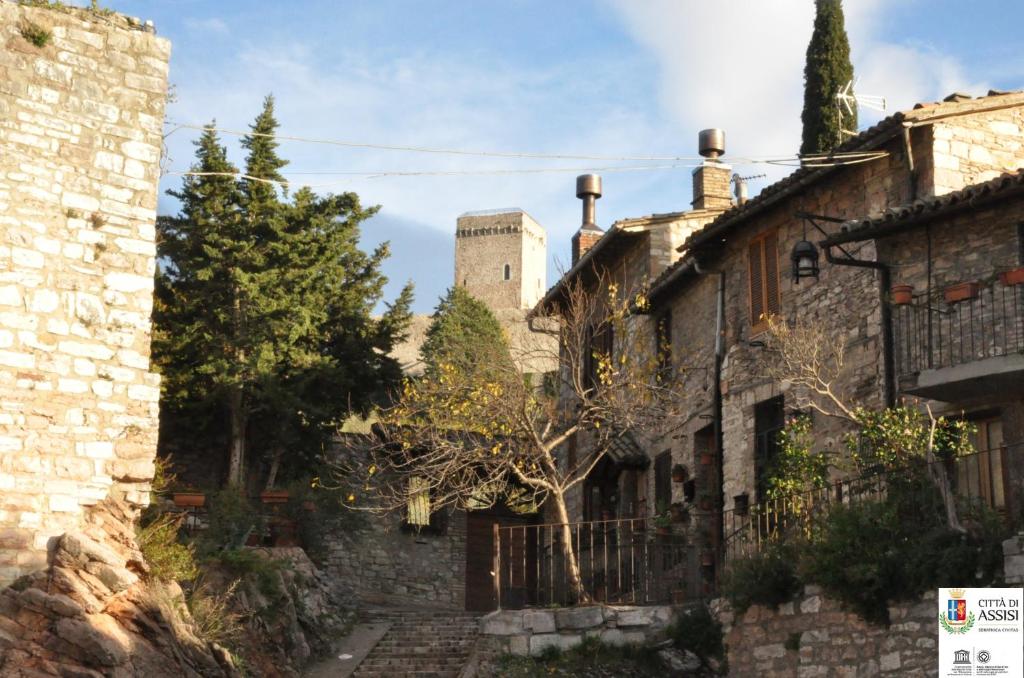 um antigo edifício de pedra com um castelo ao fundo em Da Marzietta em Assis