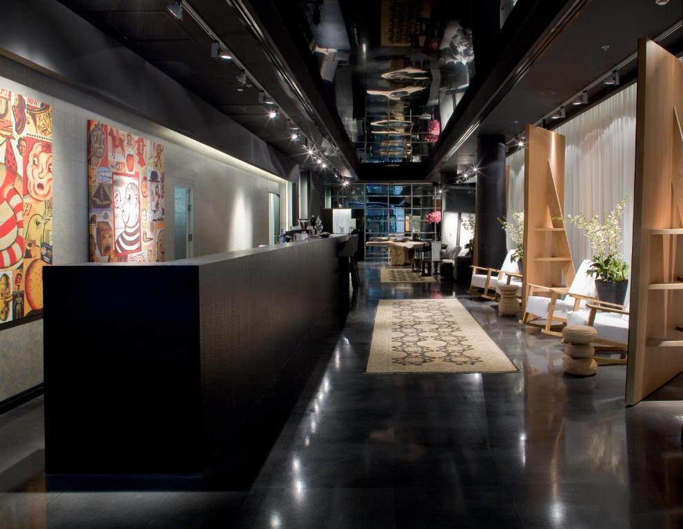 - un hall avec un long couloir avec des chaises et des tables dans l'établissement Leonardo Boutique Hotel Tel Aviv, à Tel Aviv