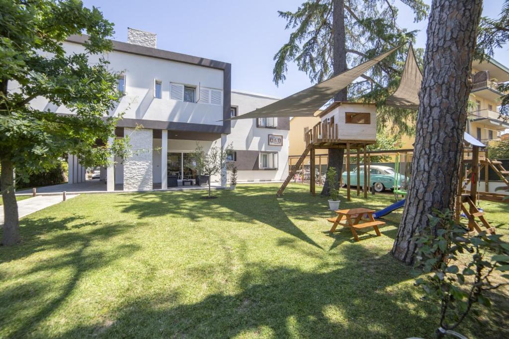 un cortile con parco giochi e albero di Anda e Rianda a Campi Bisenzio