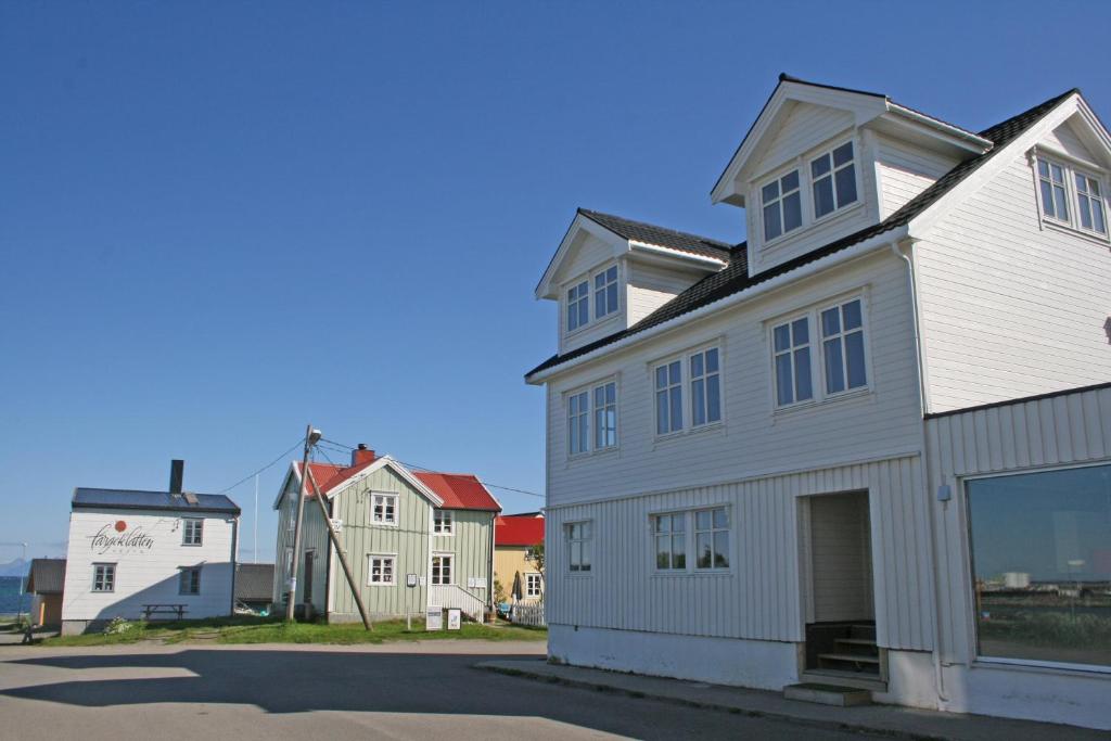 een wit huis met een garage in een straat bij Kristina Apartment & Alma House in Andenes