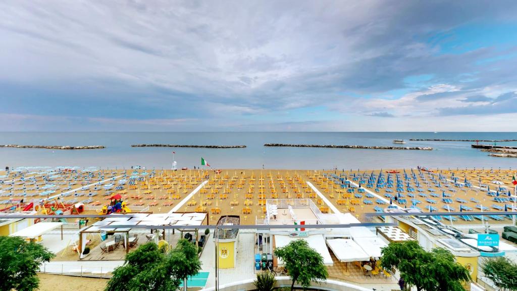 una spiaggia con molti ombrelloni e l'oceano di Bell Suite Hotel a Bellaria-Igea Marina