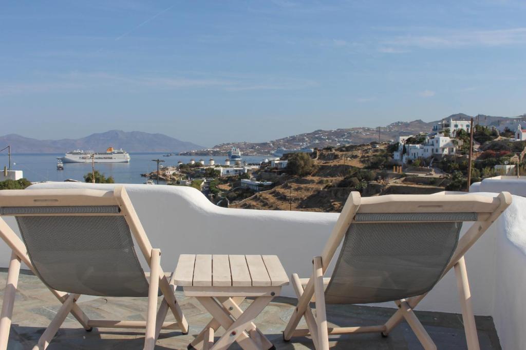 2 stoelen op een balkon met uitzicht op de oceaan bij Crystal View Mykonos in Mykonos-stad