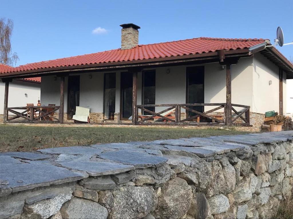 una casa con una pared de piedra delante de ella en The Refuge en Bachevo