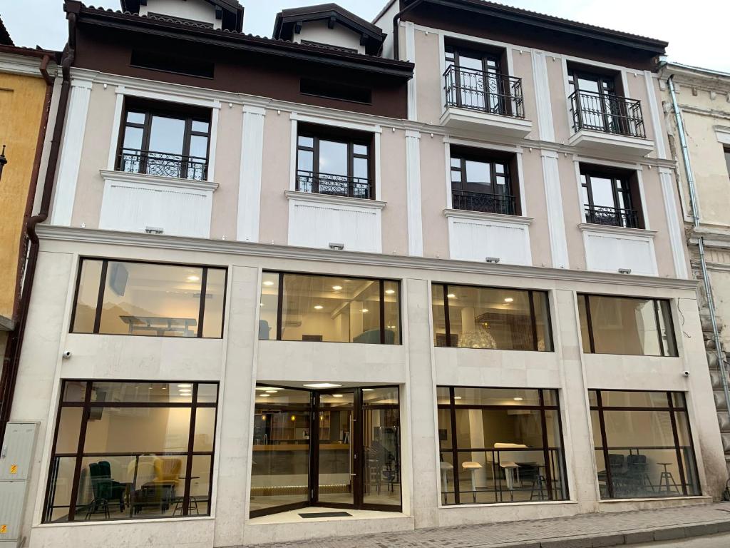 un gran edificio blanco con ventanas de cristal en ARTE Hotel rooms & apartments, en Veliko Tŭrnovo