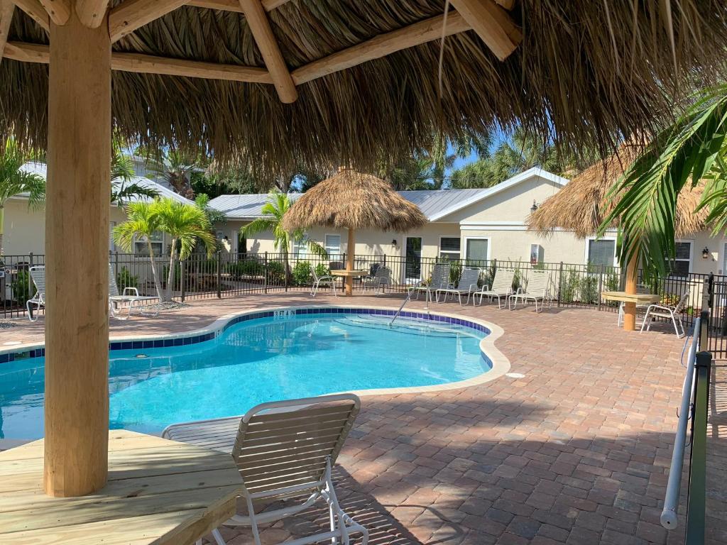 - une piscine avec une chaise et un parasol dans l'établissement Twin Palms at Siesta, à Siesta Key