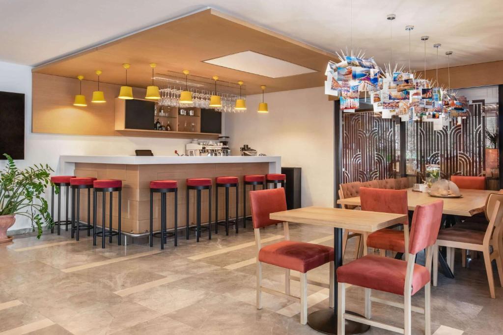 un restaurante con un bar con mesas y sillas rojas en TRYP by Wyndham Ankara Oran en Ankara