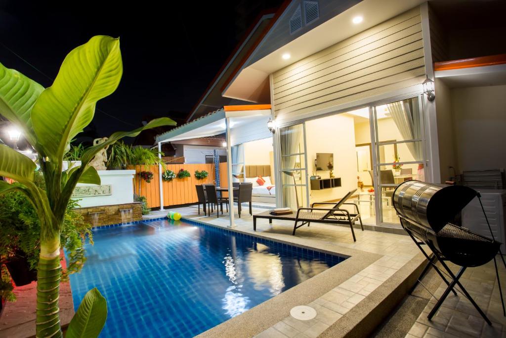 una piscina frente a una casa por la noche en Pattaya Pool Villa 39B 300 mater to beach gate, en Pattaya South