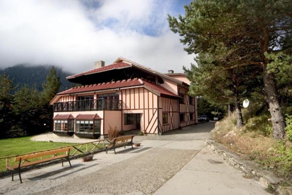 un grande edificio con due panchine di fronte di Hotel Temenuga a Panichishte