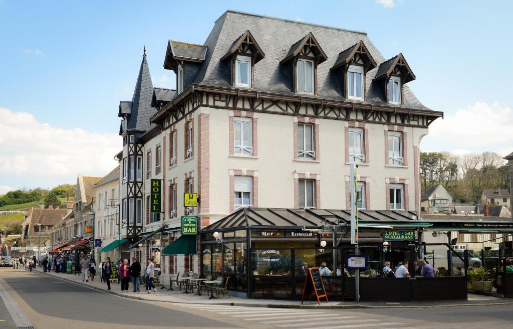 un gran edificio con techo en una calle de la ciudad en Hotel De Normandie en Arromanches-les-Bains