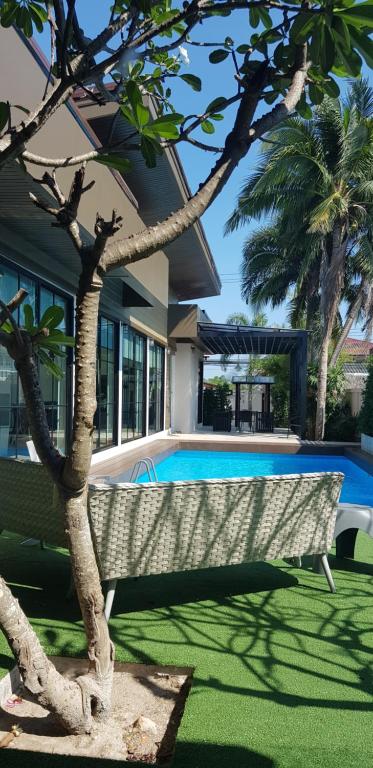 ein Schwimmbad in einem Hof neben einem Haus in der Unterkunft Banamphur Pool Villa in Na Jomtien