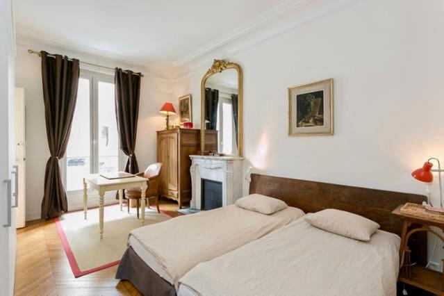 - une chambre avec un lit, un bureau et un miroir dans l'établissement Charming bedroom, à Paris