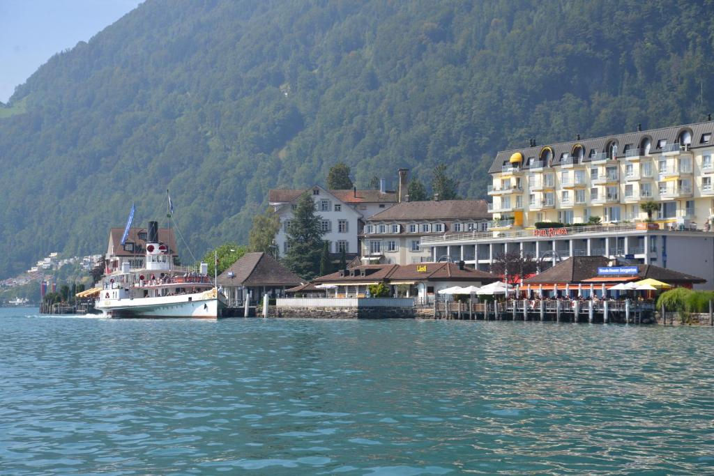 Łódź zakotwiczona jest obok miasta na wodzie. w obiekcie Seehotel Riviera at Lake Lucerne w mieście Gersau