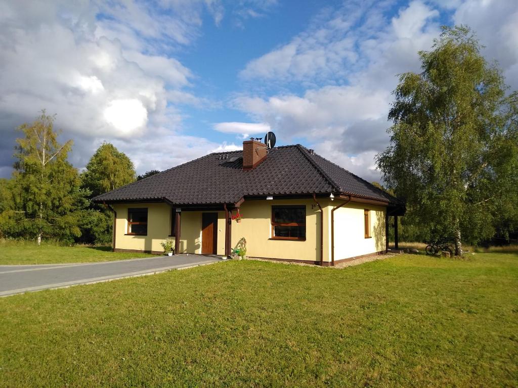 ein kleines Haus am Straßenrand in der Unterkunft Dom Wakacyjny Kuszewo in Czaplinek