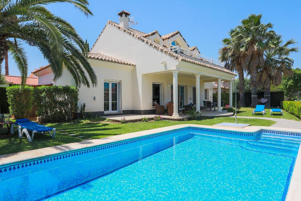 uma villa com piscina em frente a uma casa em Villa Lujo Olivanova Golf MET em Oliva