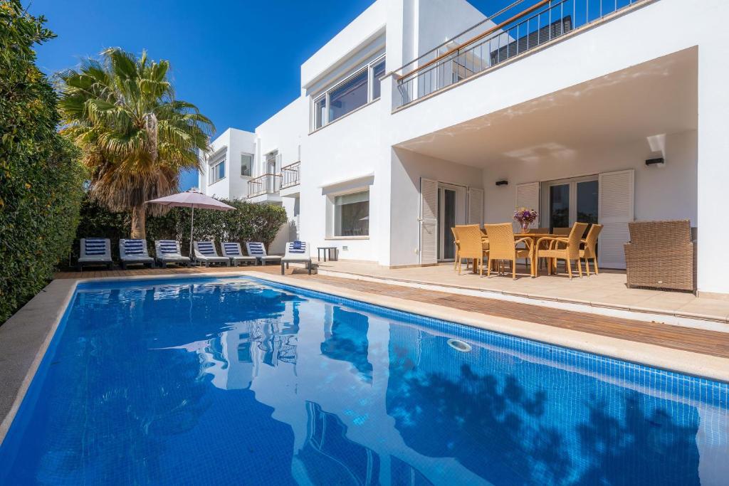 una villa con piscina di fronte a una casa di Villa Costa Eugenia a Cala d´Or