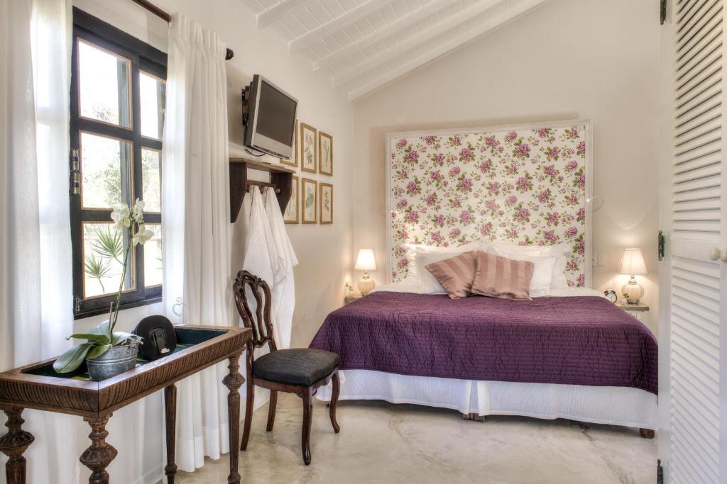 1 dormitorio con 1 cama de color púrpura y 1 silla en Villa Balthazar en Búzios