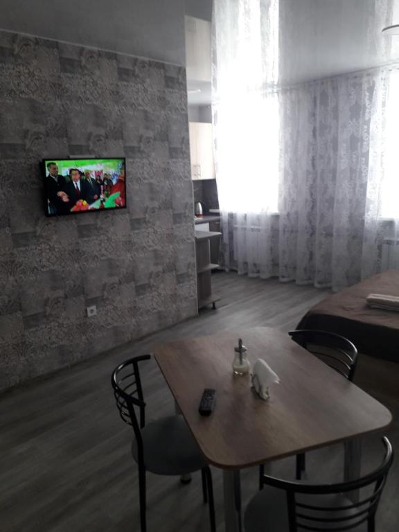 Zimmer mit einem Tisch und einem TV an der Wand in der Unterkunft Studio on Stefan 37 in Bălţi