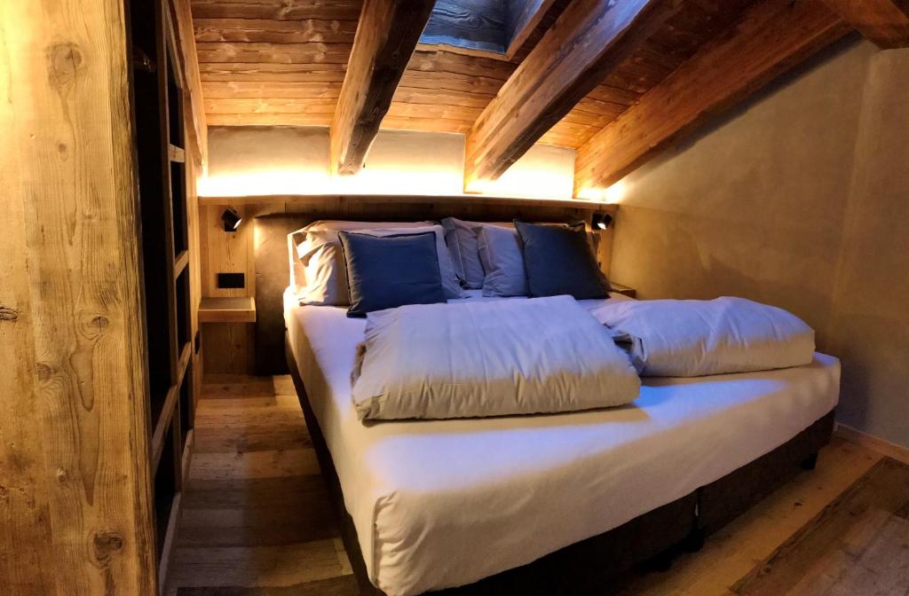 Cama en habitación pequeña con techo de madera en Hotel san Vitale, en Bormio