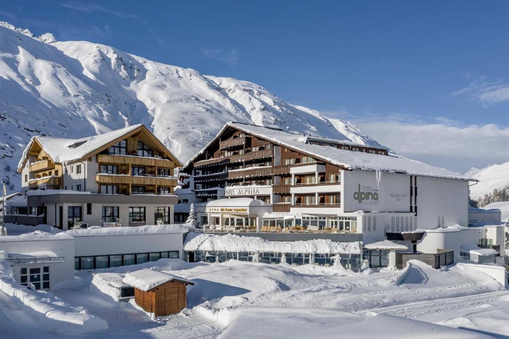 un hotel en la nieve frente a una montaña en Hotel Alpina deluxe en Obergurgl