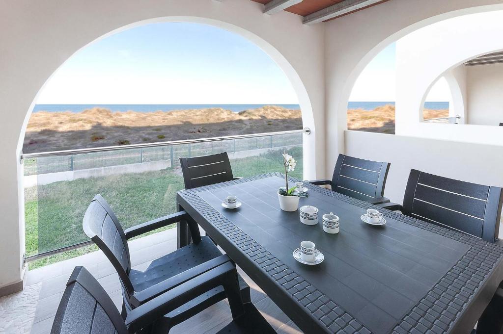 uma mesa preta e cadeiras numa varanda com vista para o oceano em La Mar de Olas em Oliva